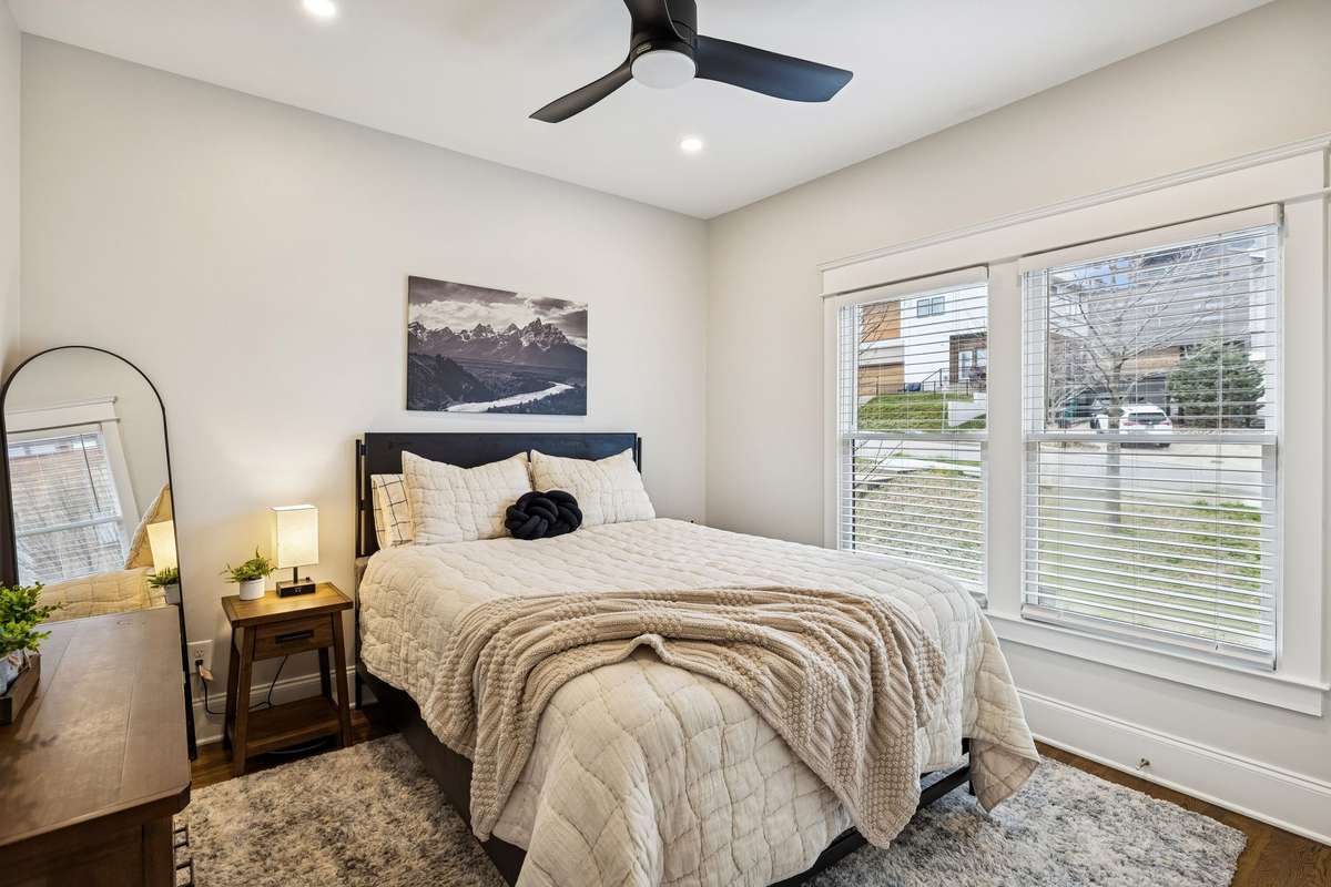Secondary bedroom with large windows, natural light, and a clean, neutral palette.