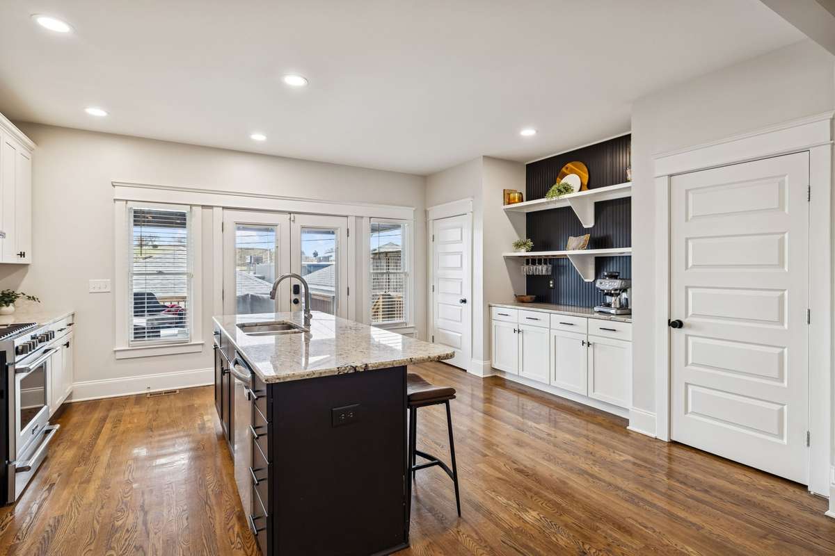 Bright kitchen with excellent natural light, open shelving, and a built-in coffee/bar station.