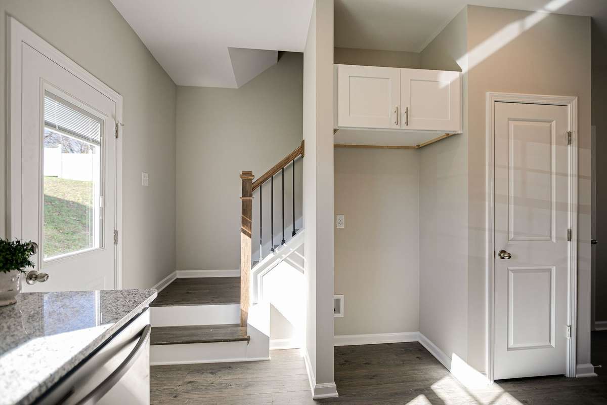 Stainless Steel Refrigerator has been installed between stairs and pantry door.