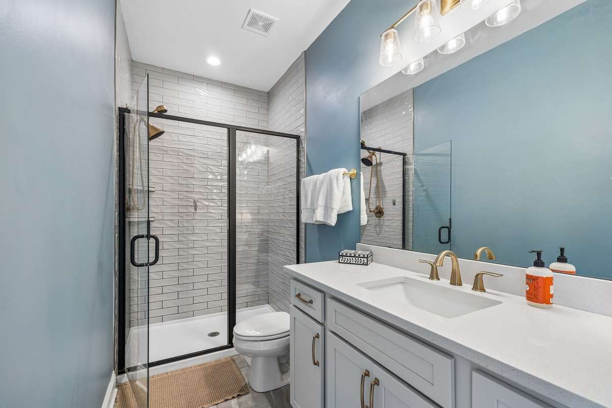 Shower with Floor to Ceiling Tile Surround and a Linen Closet