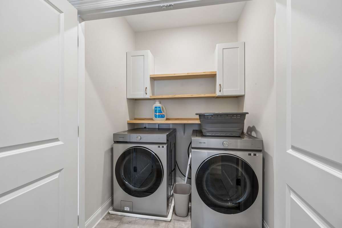 Step in Laundry Closet complete with shelves and cabinets recently added.  Not to mention the Washer and Dryer remain with the property.  If you were to build new construction,  you would have to purchase these.