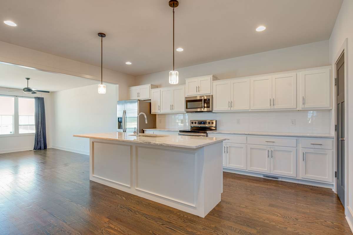 Entertainer's dream kitchen with bright white cabinets and tons of natural light beaming in!