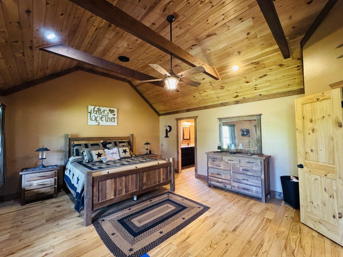 The Primary bedroom on the main floor of the home features vaulted wood ceilings, an extra extra large walk-in closet, dual vanities, toilet room, and a separate toilet room for extra privacy.