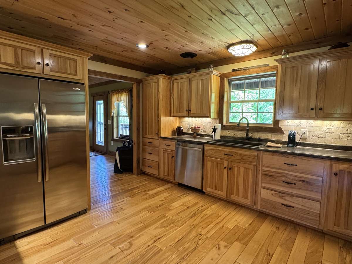 This chef style kitchen features built in stainless appliances, large pull out bottom drawers, spice racks, corner roundabouts, and a large pantry cabinet.