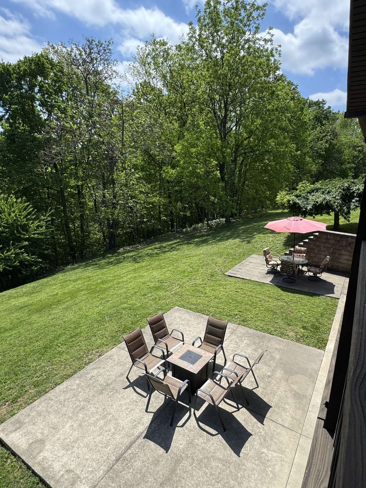 Photo of the back taken during the summer so you can see the green trees and grass, and look forward to warmer days out here!!