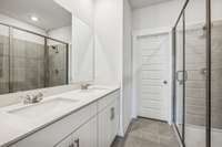 Spa-like en suite bath features a large walk in shower, double bowl vanity, and separate water closet.