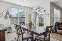 The dining room features two windows and the patio door, filling the space with natural light.