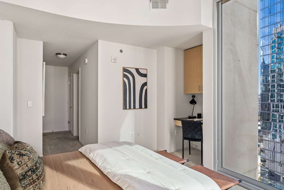 Primary bedroom with built-in desk space, expansive closet and city views