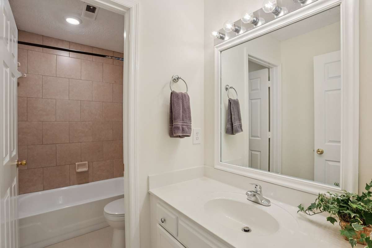 The hall bath has a freshly glazed tub and tile surround.