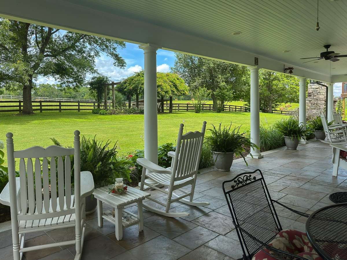 This sweeping COVERED BACK PORCH awaits you with dreamy, PRIVATE views in every direction...birdsong and lush landscaping add to this al fresco dream space...