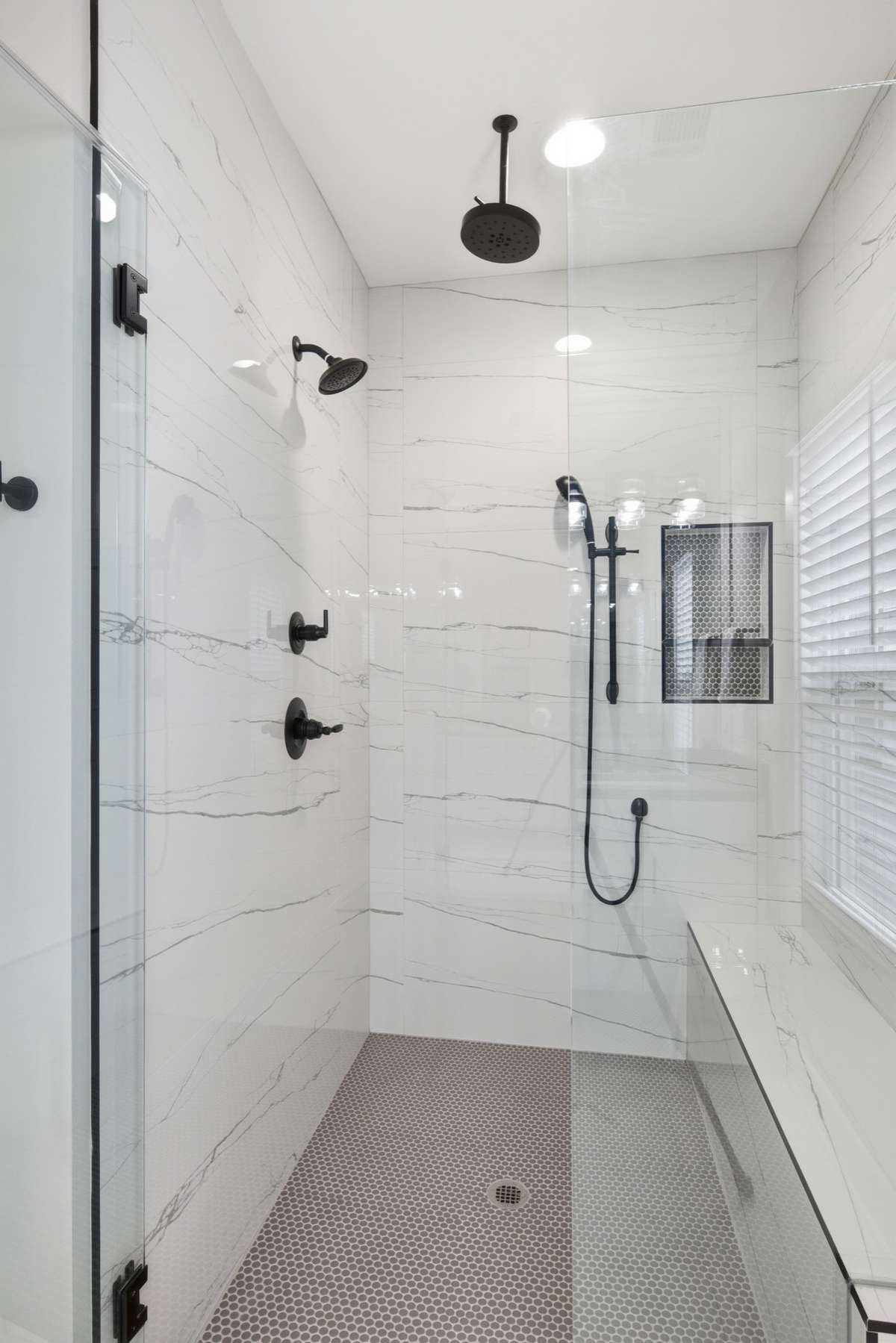 Tile surround (floor-to-ceiling), with tiled bench seat and shower niche.