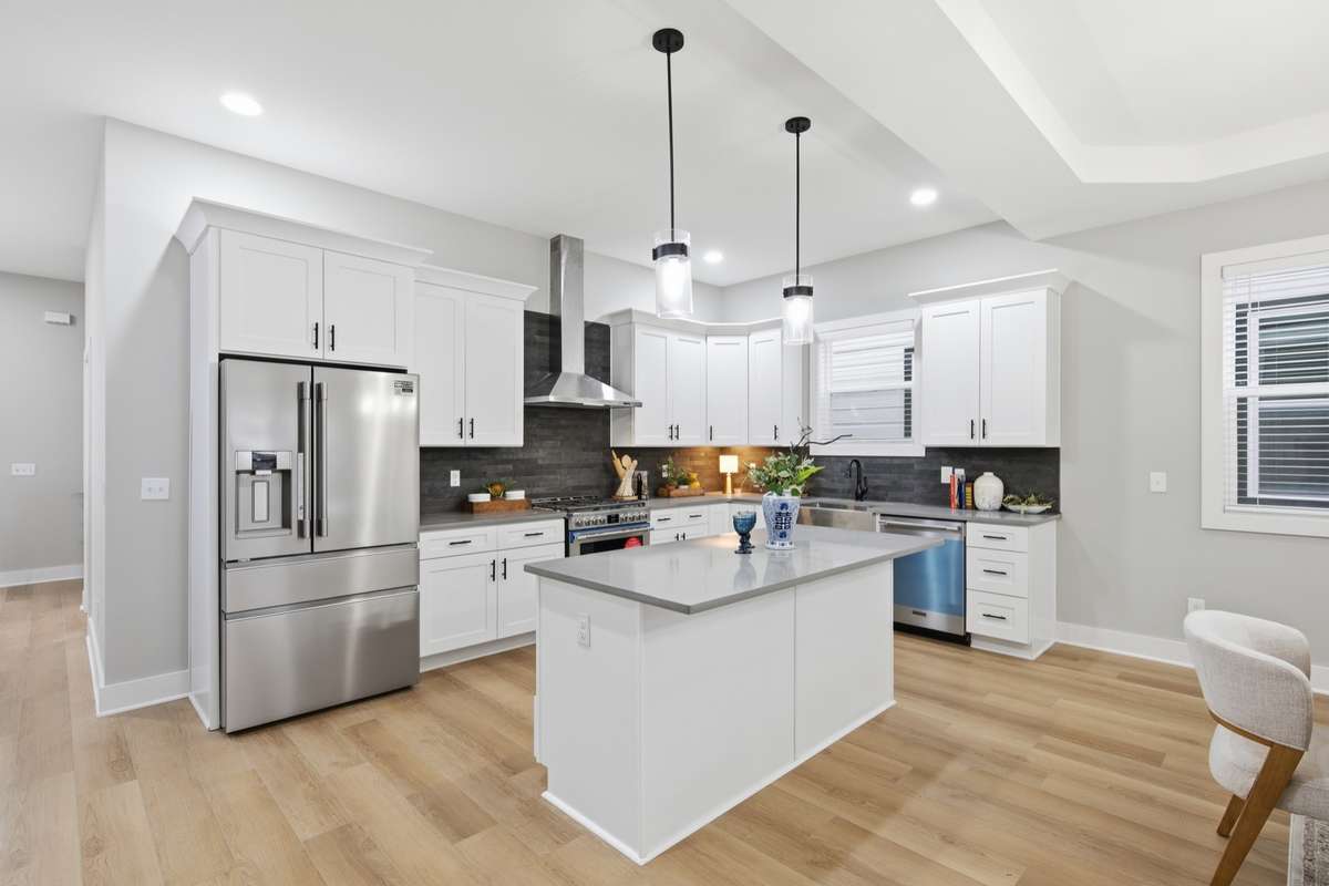Pull up to your kitchen island seating for a bite! The new refrigerator is conveniently provided by the builder and can remain with the home.
