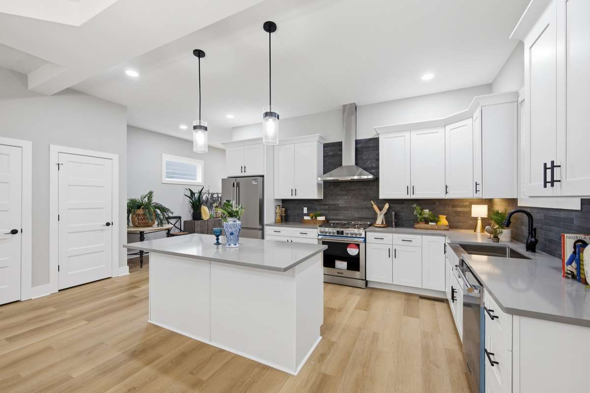 The spacious kitchen is great for cooking space and gathering when hosting family and friends. Note the stainless oven hood vent.