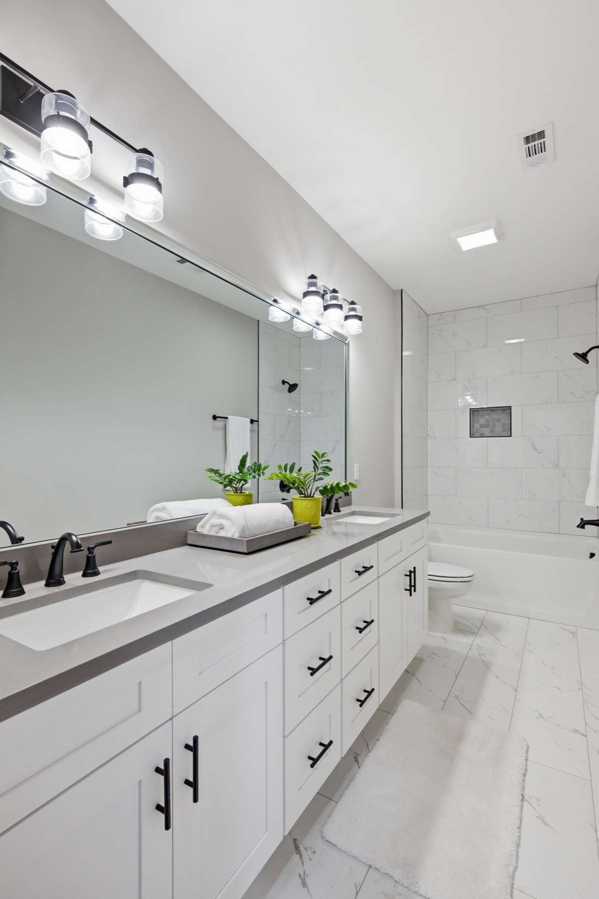 Double vanity and soaking tub/shower combo! Detail not to be overlooked - the tile stretches to the ceiling!