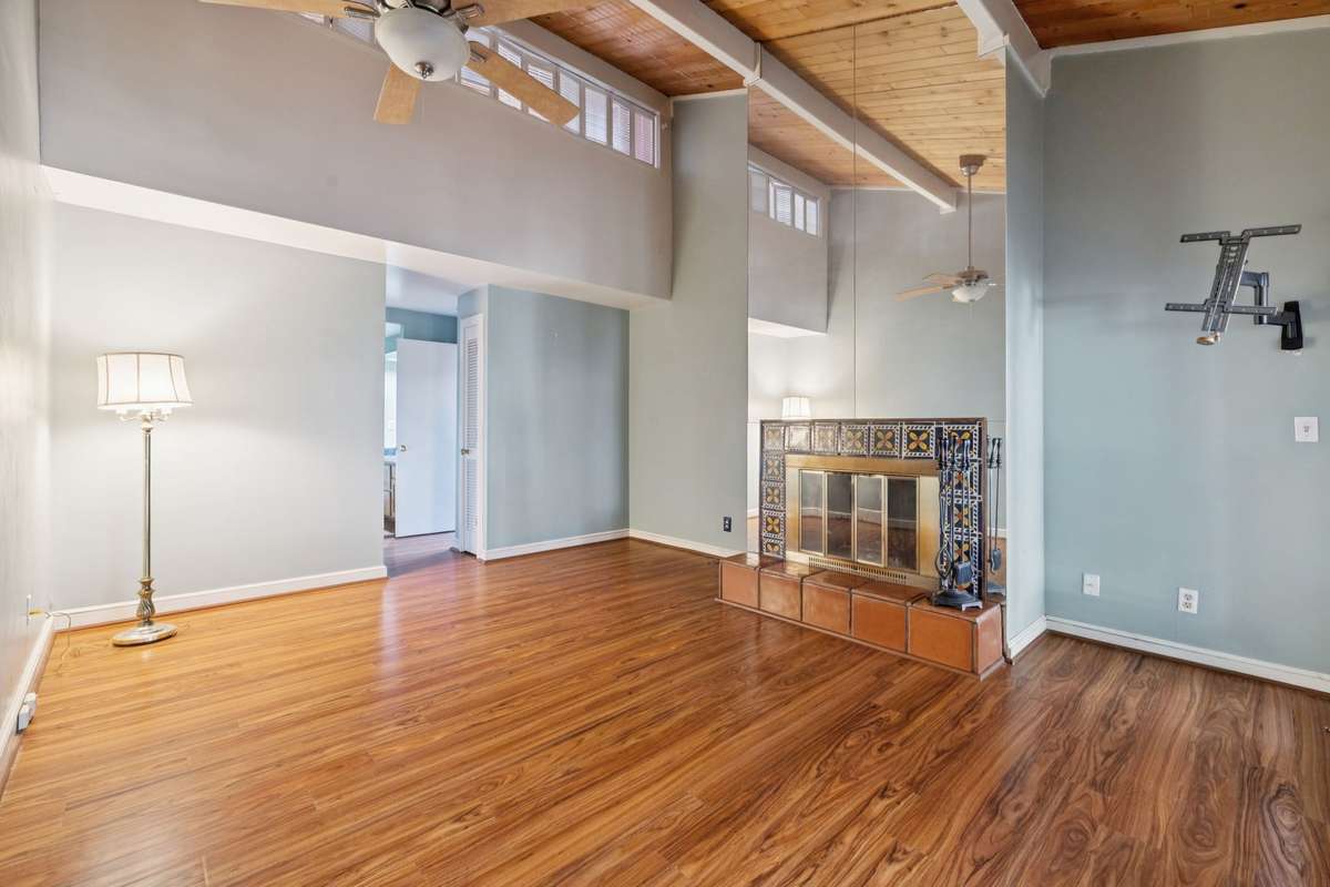 Primary Bedroom with beautiful hardwood that leads out into screened in porch.