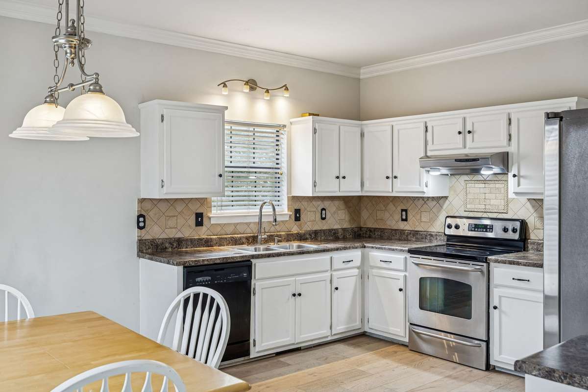 Open kitchen with spacious eat-in dining area features new lighting, fresh paint, and fresh white cabinetry! 7701 Poplar Ridge Drive, Nashville, TN 37221