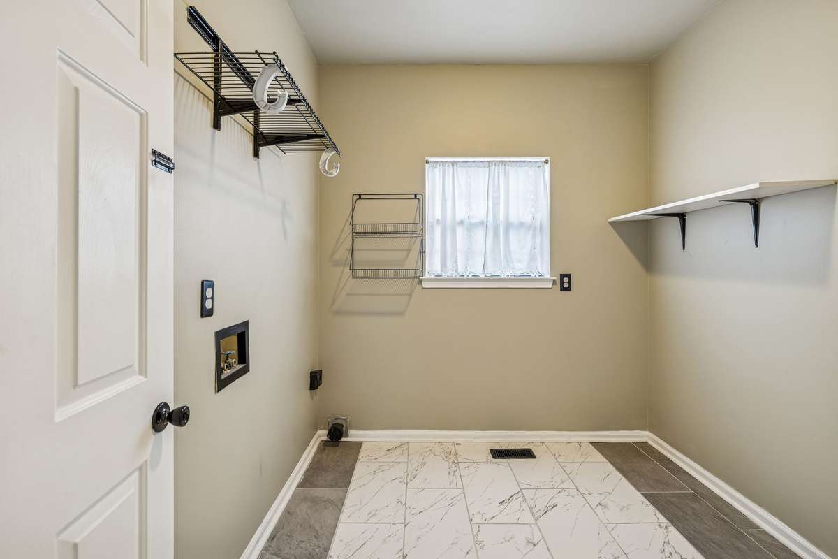 Over-sized utility room with new flooring and shelving for your laundry supplies! 7701 Poplar Ridge Drive, Nashville, TN 37221