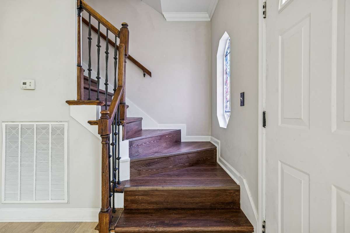 Hardwood treads with wrought iron railing lead to the second floor. 7701 Poplar Ridge Drive, Nashville, TN 37221
