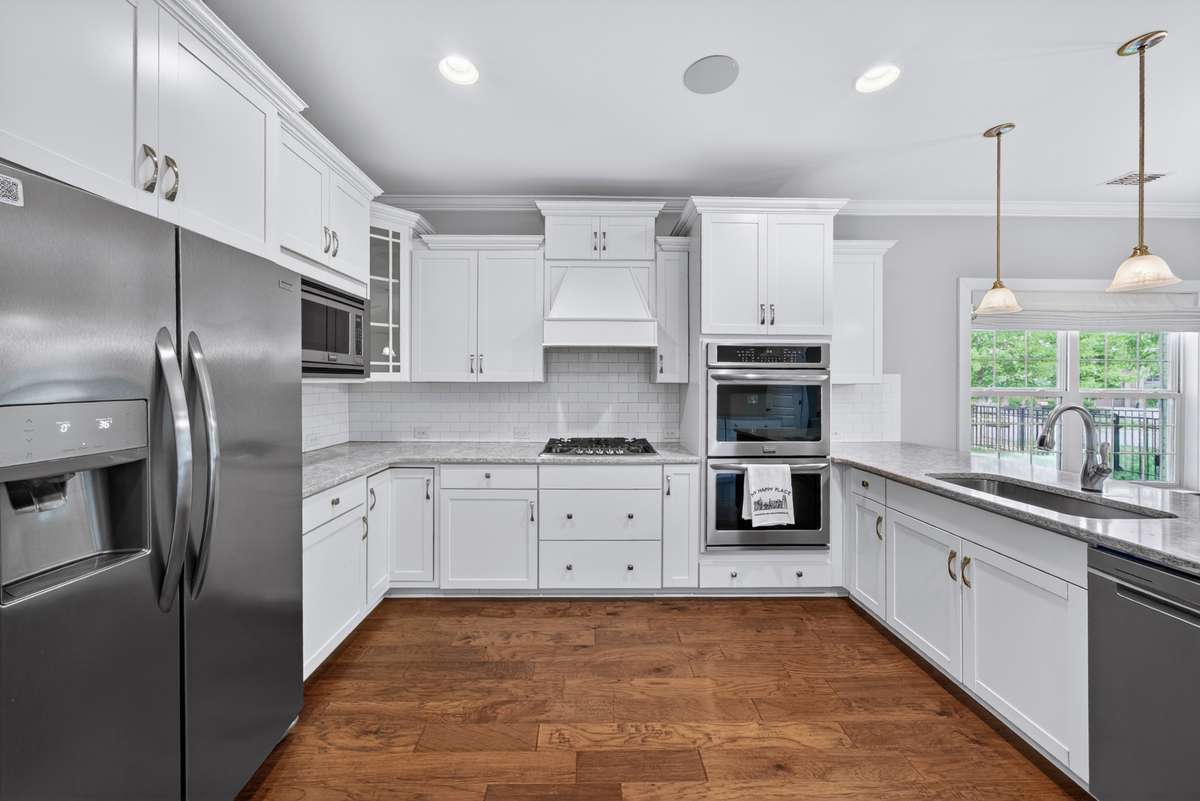 The upgraded kitchen features stainless appiances, with double ovens, cooktop, microwave, dishwasher, and fridge (stays with house).