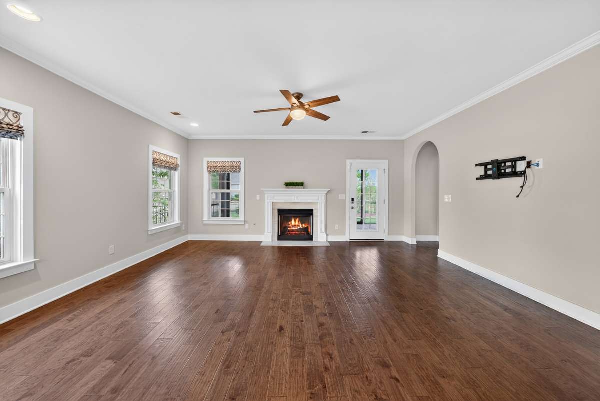 The spacious living room is anchored by a quaint fireplace, creating a warm and inviting space to gather and unwind.