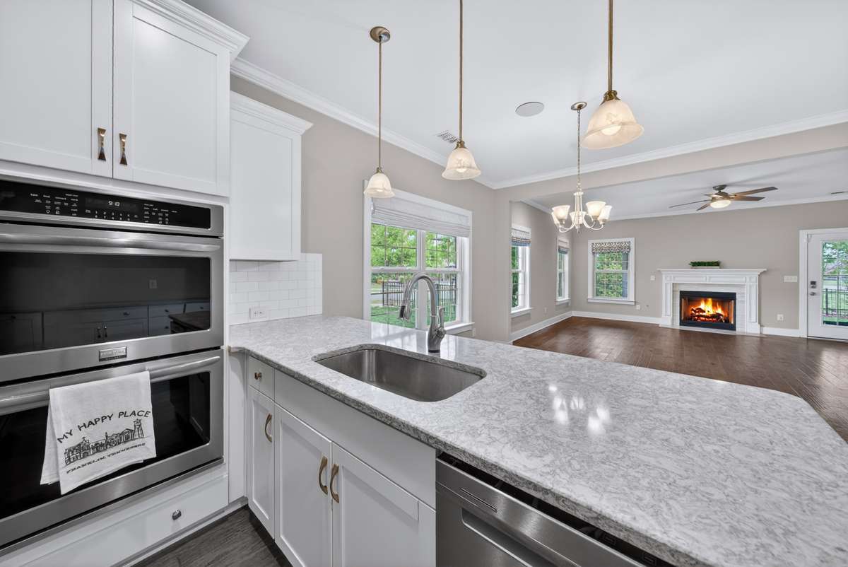 Angled View (your uploaded)
Bright, open kitchen with large island, pendant lighting, and seamless flow into the main living areas.
