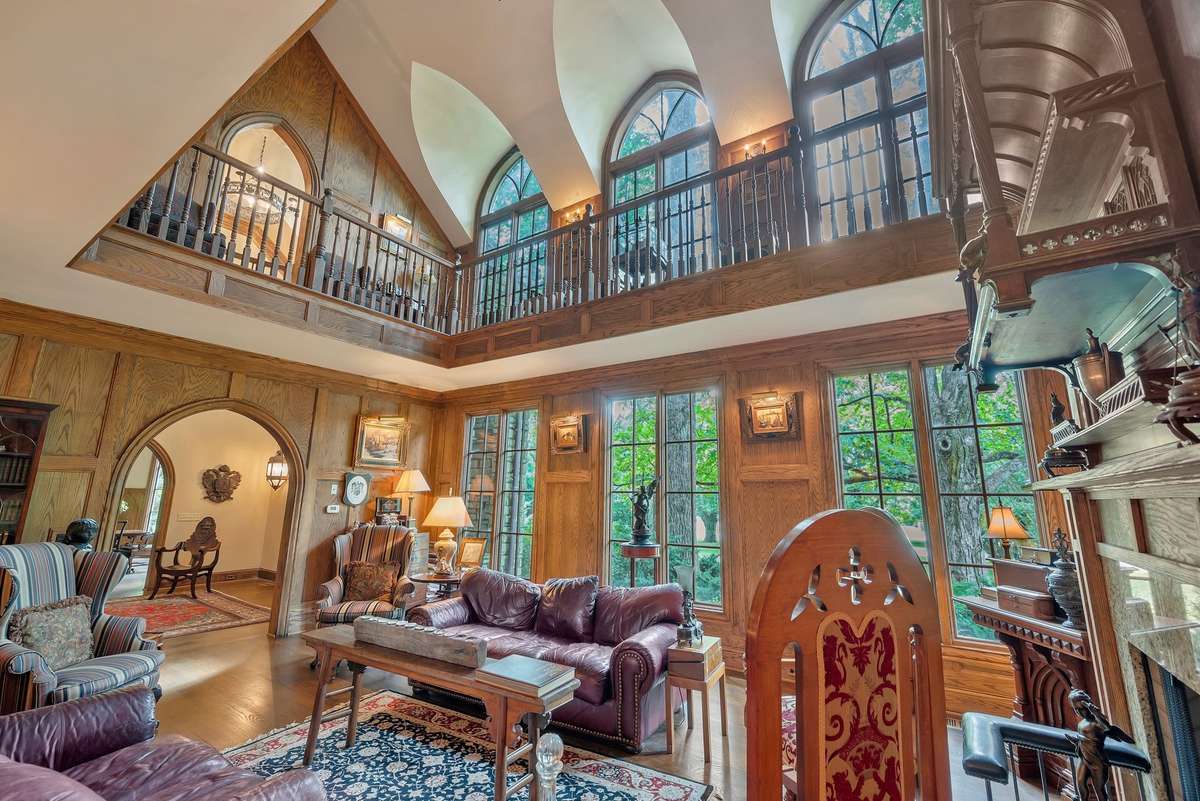 Mounted beside or between the Gothic arches, sconces subtly highlight their elegant curves and pointed peaks