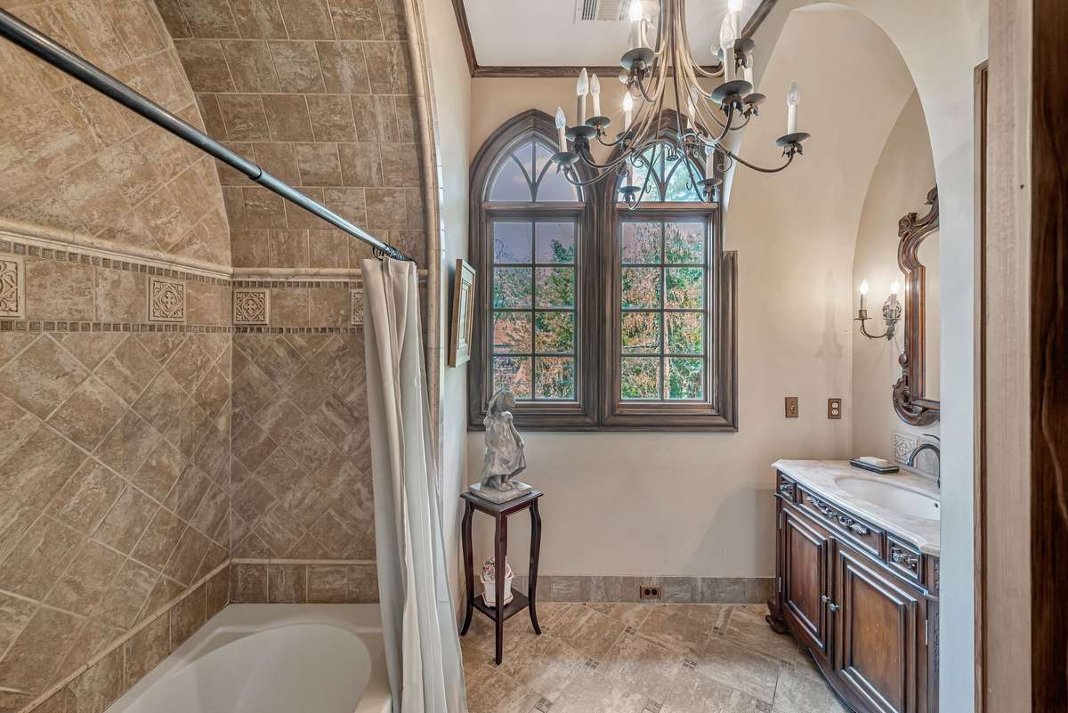 Bathroom off the bedroom. The tilework adds both texture and elegance, The arched windows bring in lots of natural light. There is a beautifully appointed dressing area perfect for getting ready in style.
