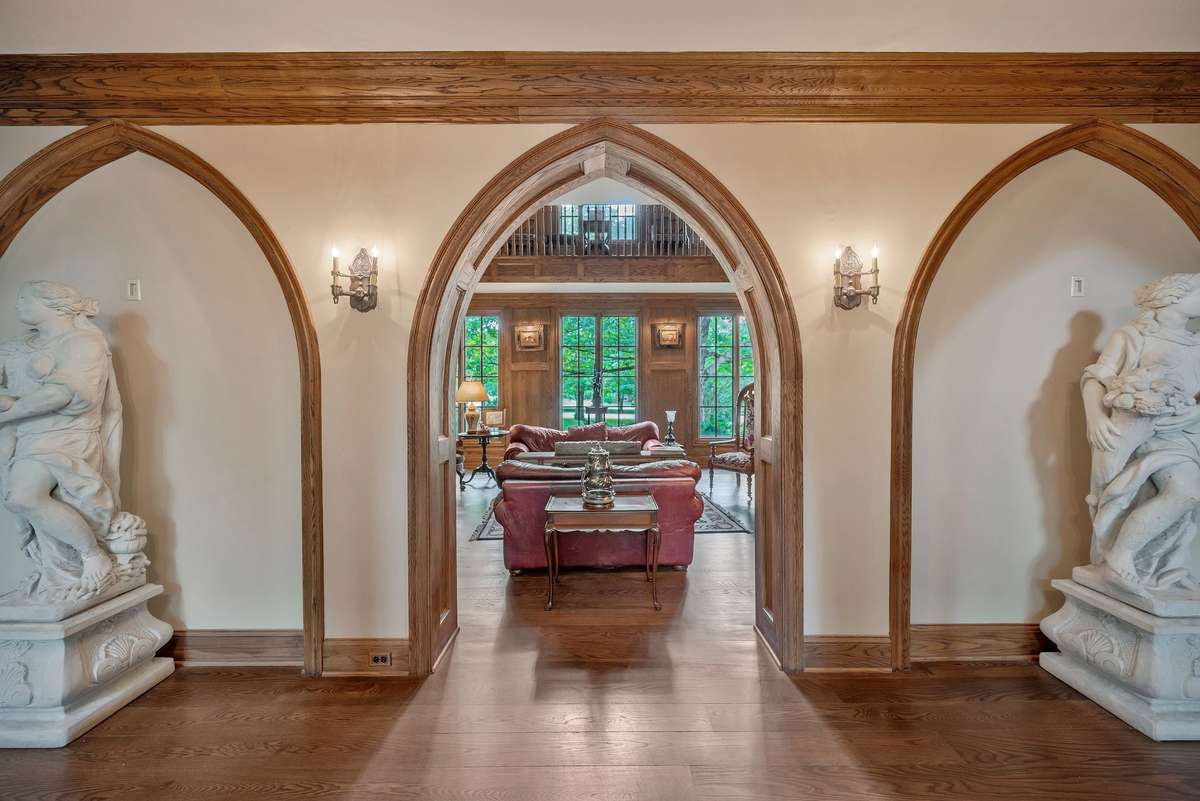 The hallway is wide and long with lined on both sides with a sequence of pointed Gothic arches. One side is the library and the other side is the Great room.