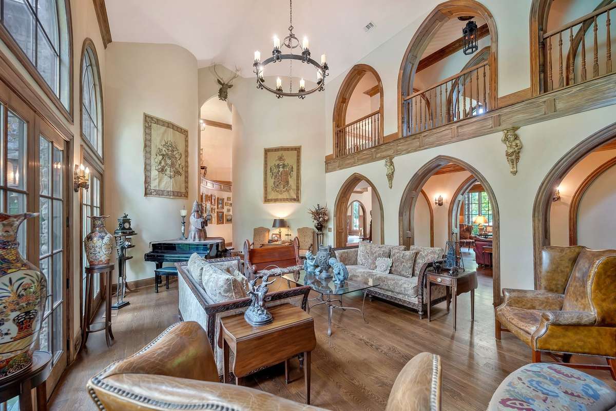 A series of elegant arched hallway openings on both levels line the walls between the library and great room