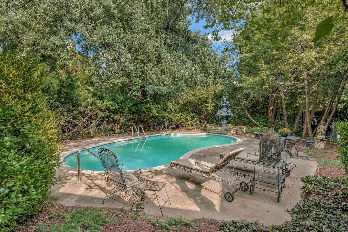 There is a fountain at the edge of the pool