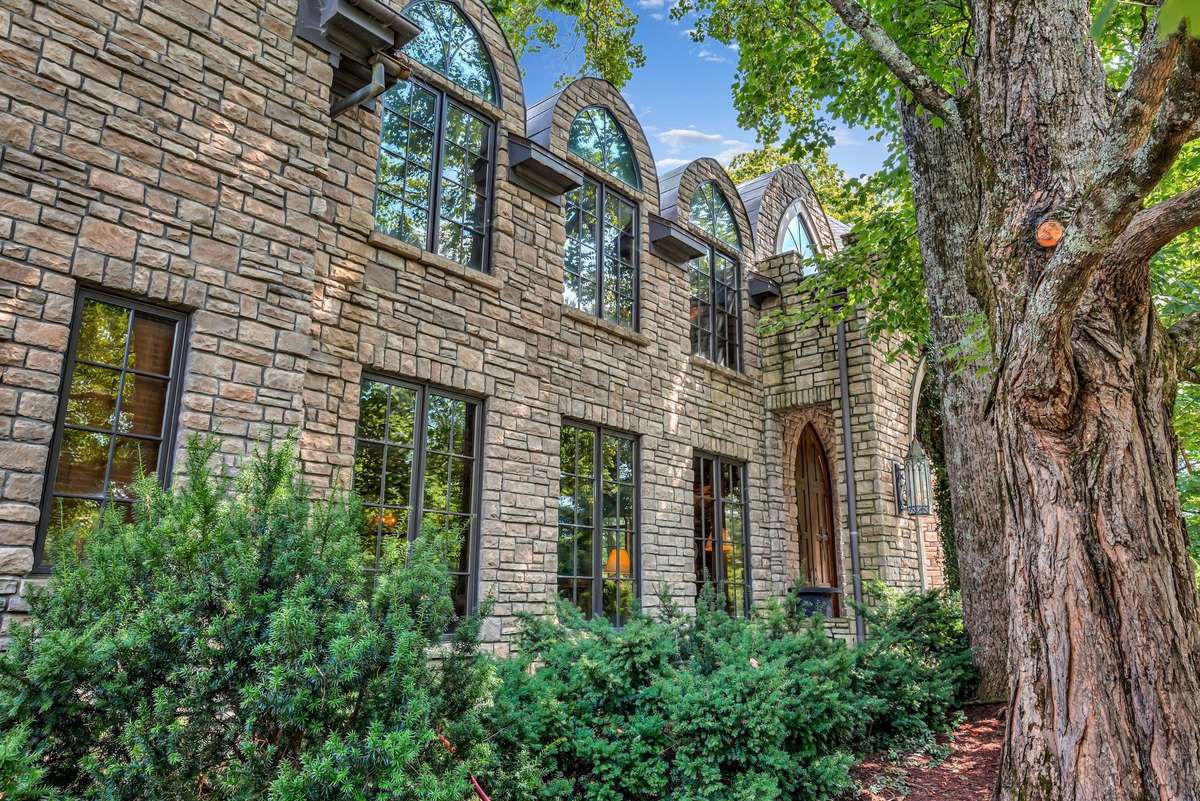 The cathedral-style windows echo a style right out of Hogwarts. Majestic old trees surround the home which frames the property with natural elegance and offers a sense of history and grounding