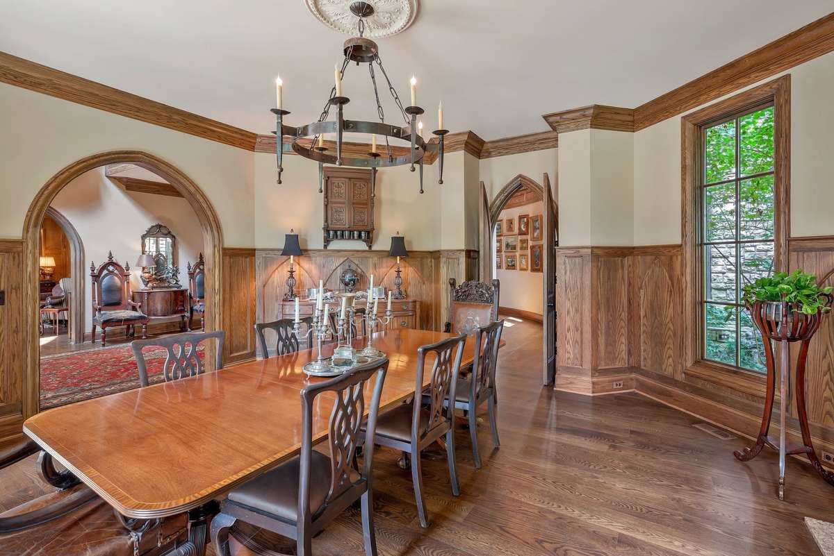 Hexagon shaped dining room is an architectural gem- each of the six angled walls contributes to a cathedral like geometry room w/ wood paneling that climbs the walls.