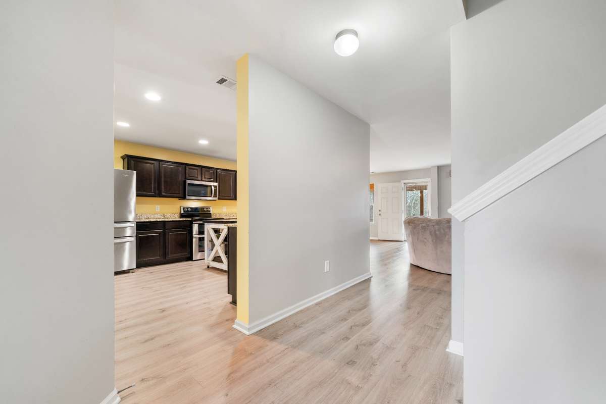 From the front door into the kitchen, beside the stairs.