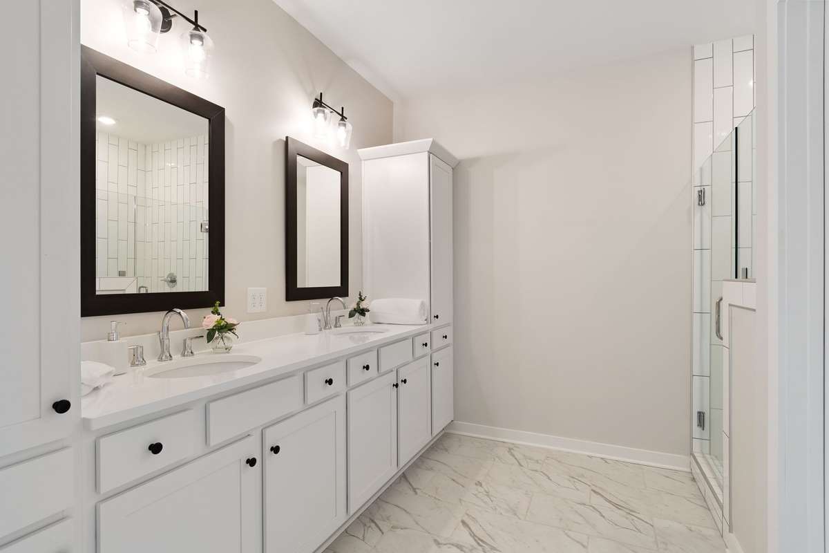 The primary bathroom with dual vanities has a tremendous amount of built-in cabinetry.