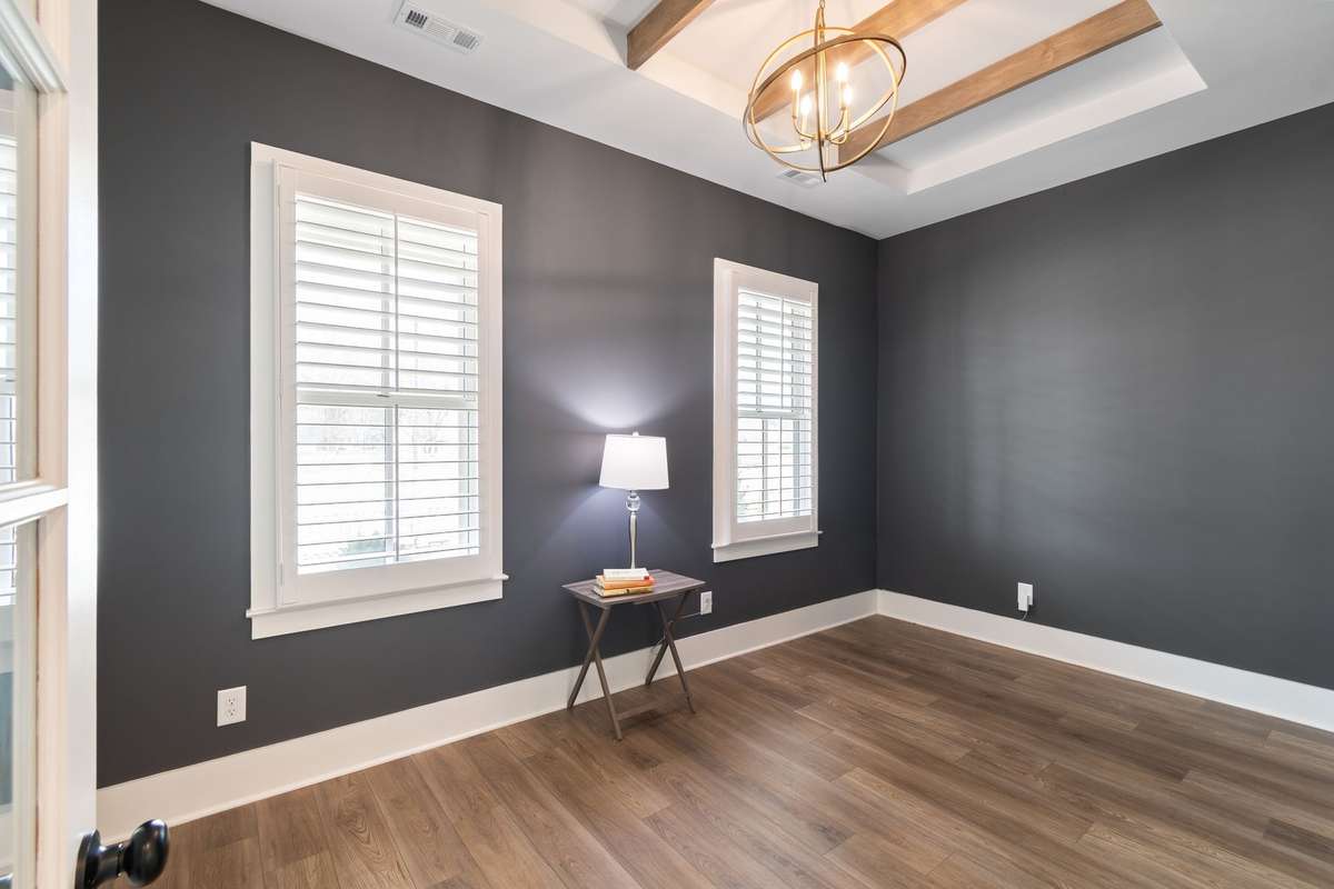 The office/music room/formal living room space with loads of windows, beam ceiling and designer lighting.