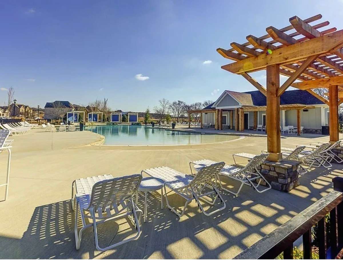The clubhouse pool offers abundant seating and overlooks a beautiful lake.