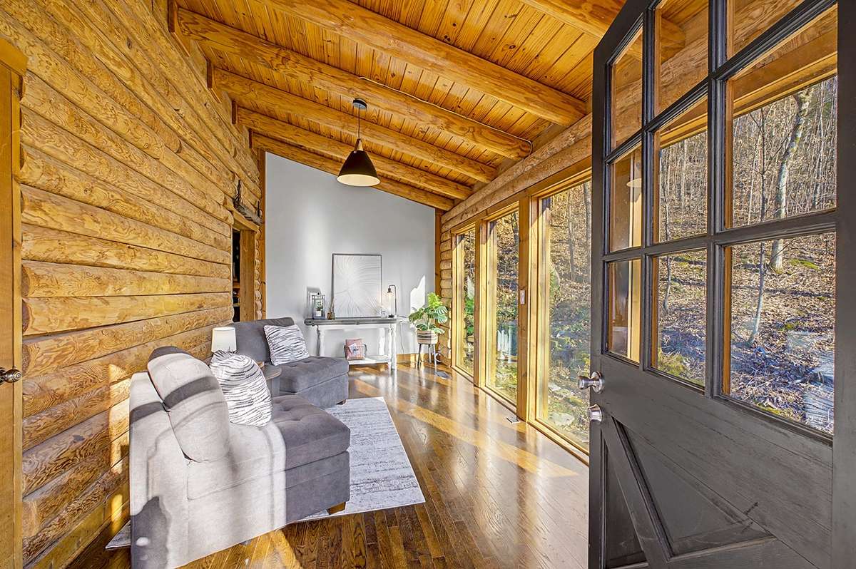 What an entrance! Sun-filled space w/floor-to-ceiling windows & vaulted ceiling