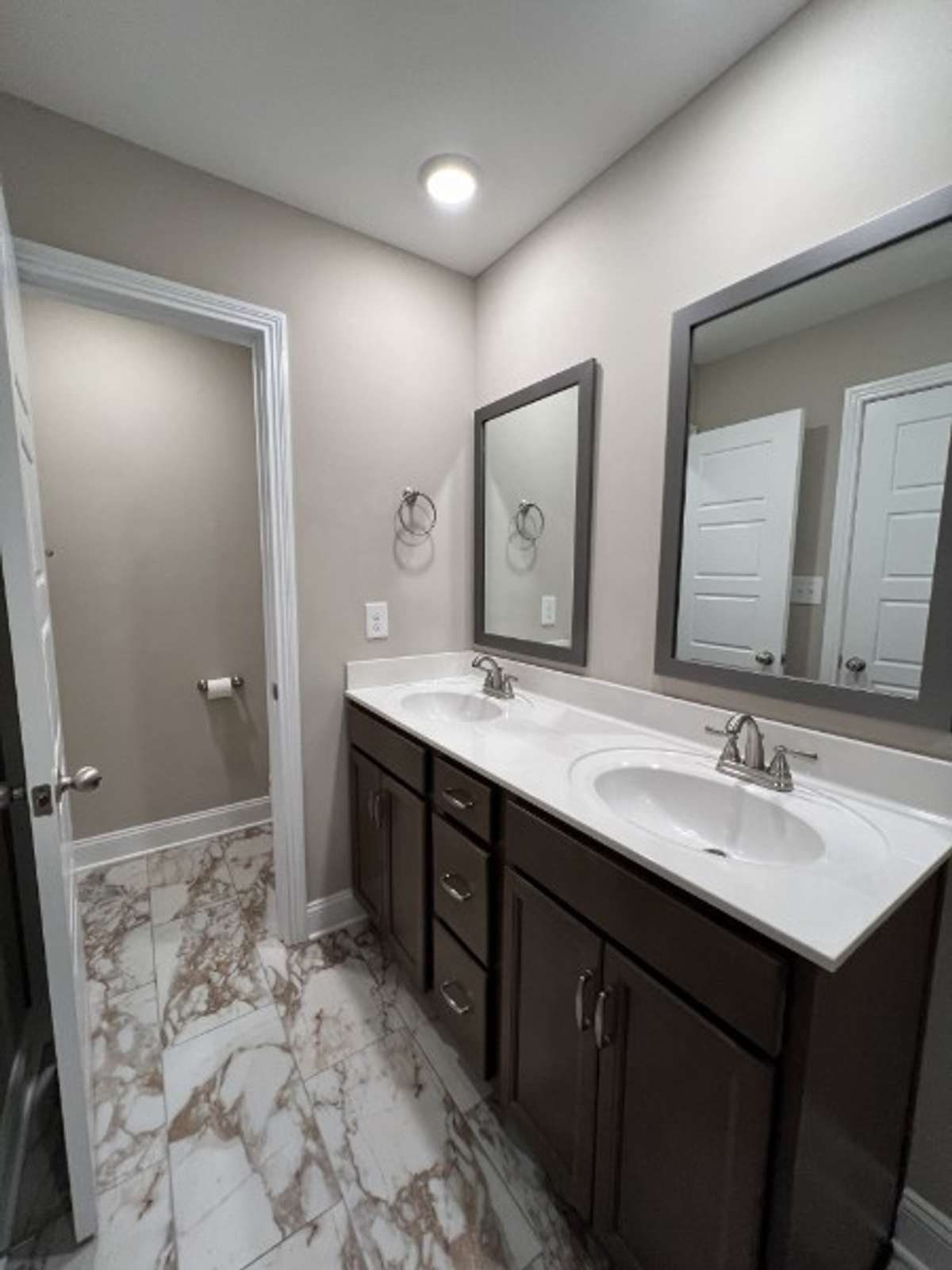 Primary bathroom with dual sinks, a private toilet room & a large shower.