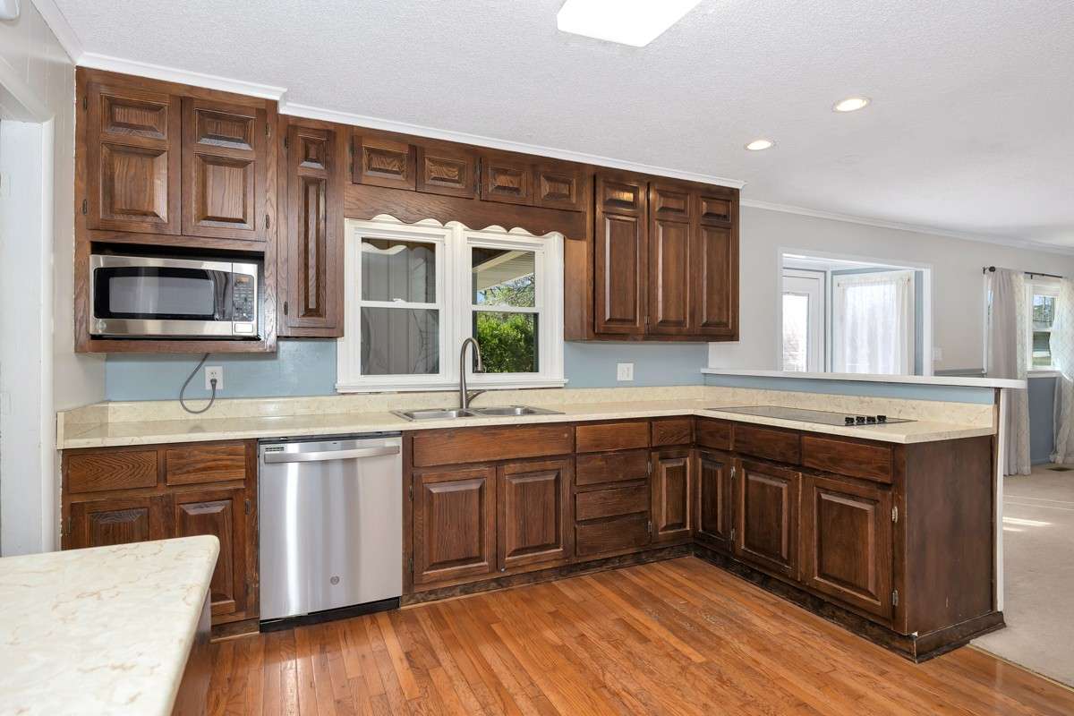 Kitchen- wood flooring, crown molding, wood cabinetry, stainless steel appliances, recessed lighting