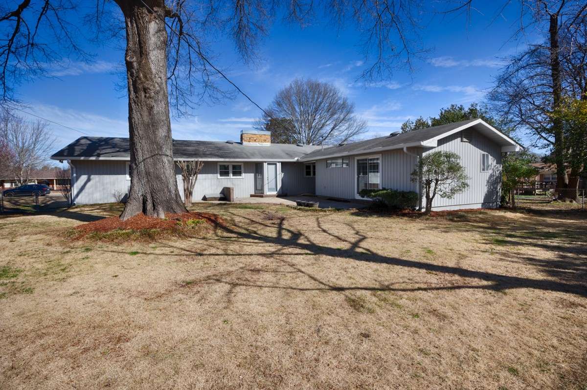 Back of house - Patio, fenced yard, mature trees provide shade