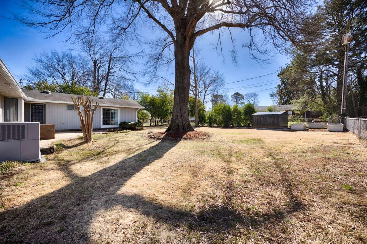 Back yard- Patio, fenced yard, mature trees provide shade, storage shed, raised greening beds