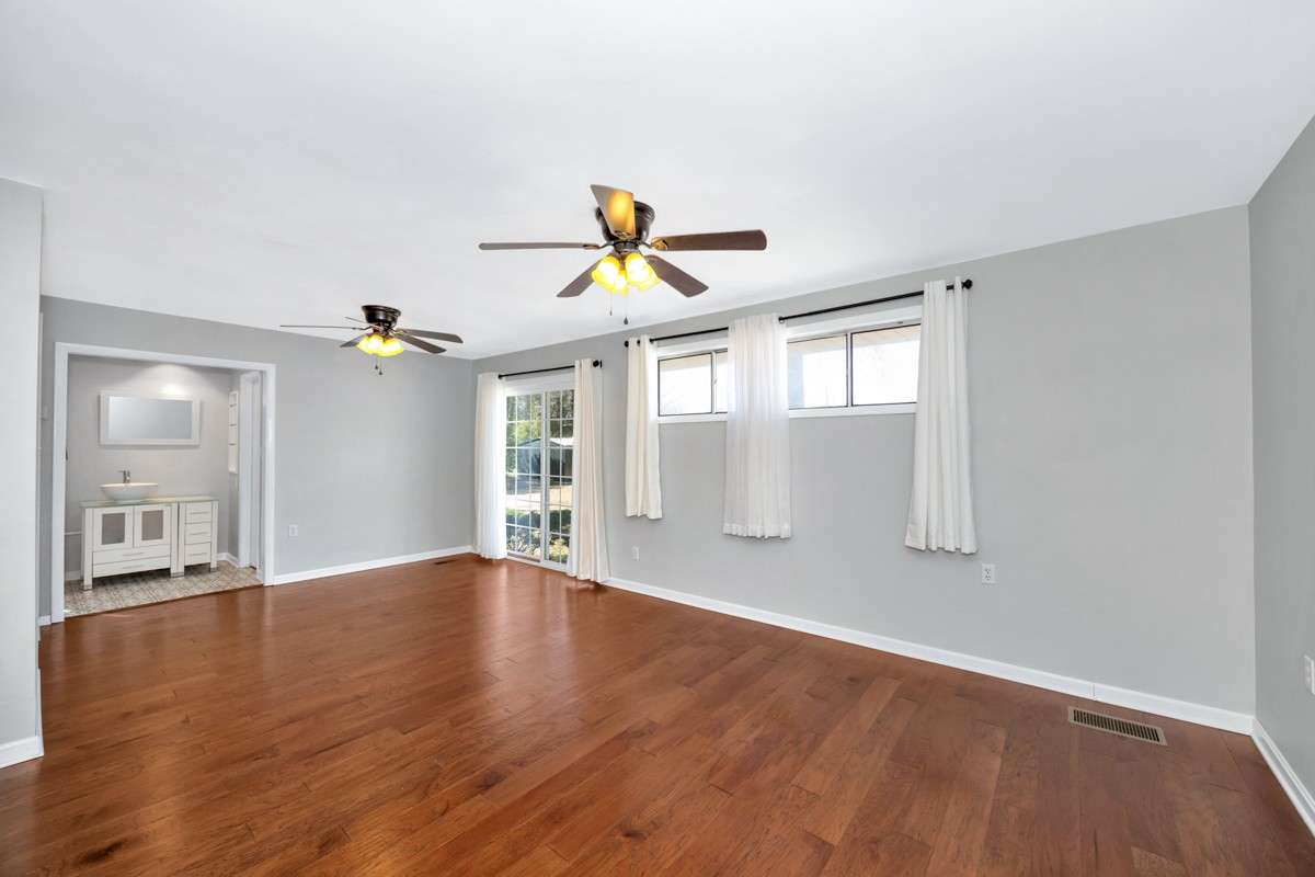 Primary Bedroom- Wood flooring, ceiling fans, 3/4 bath