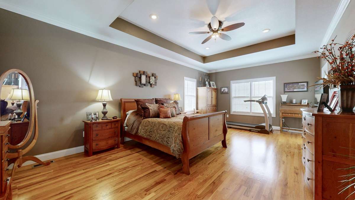 Large bedroom with tray ceiling and tons of natural light.