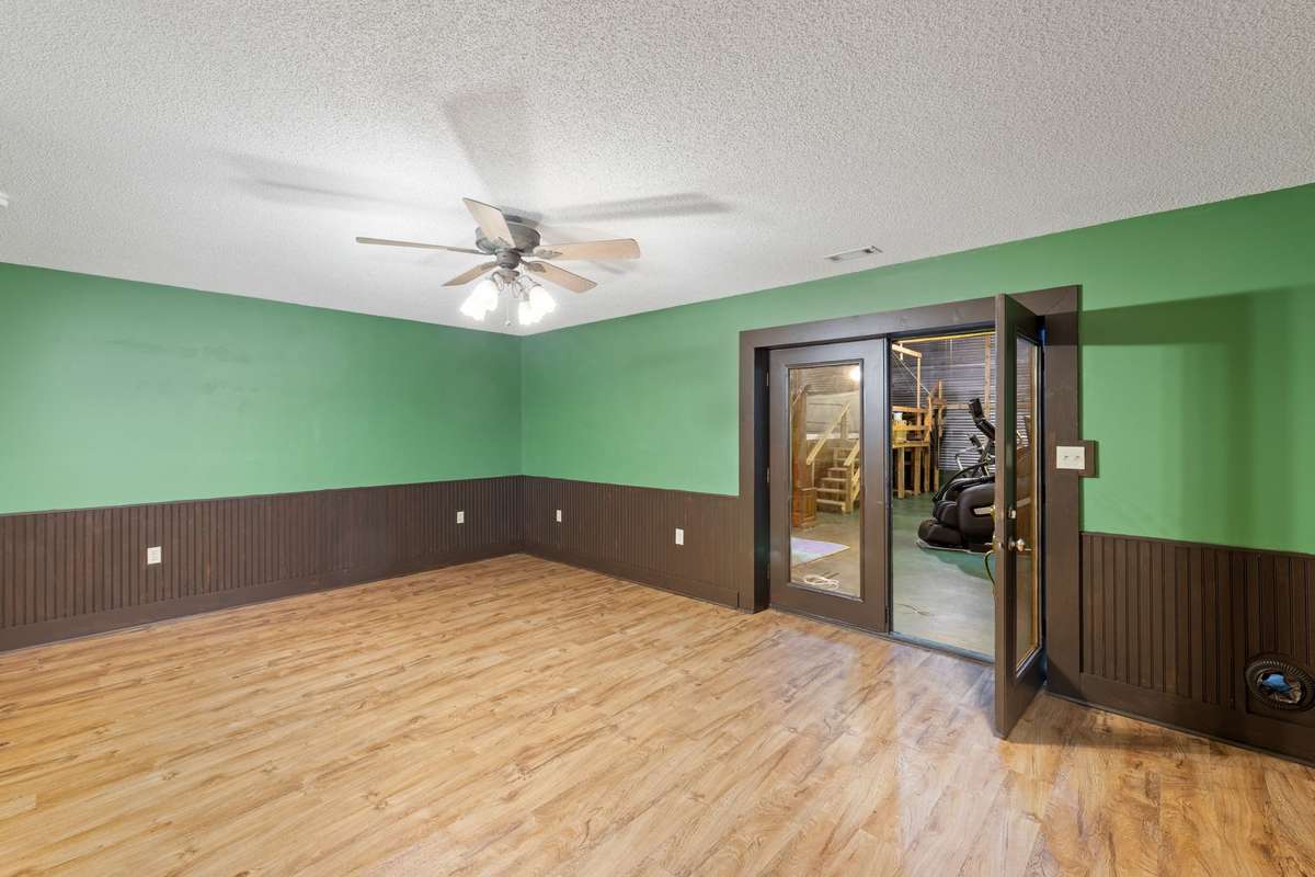 Den - located in basement - with adjacent full bathroom - French doors lead into the pool room