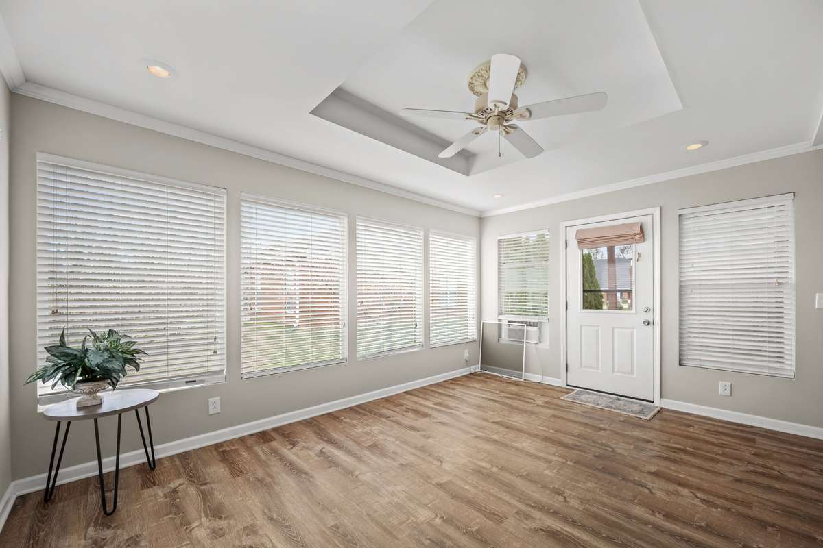 Sunroom on rear of house with vaulted ceiling and ceiling fan.
