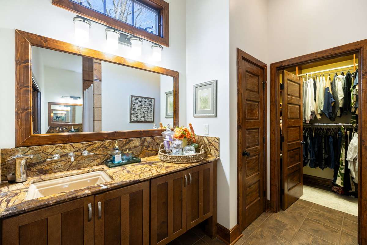 There are two separate vanities with granite countertops and a separate sink in each, and that gorgeous wood cabinetry and doors throughout!  You can catch a glimpse of the wrap-around walk-in closet.