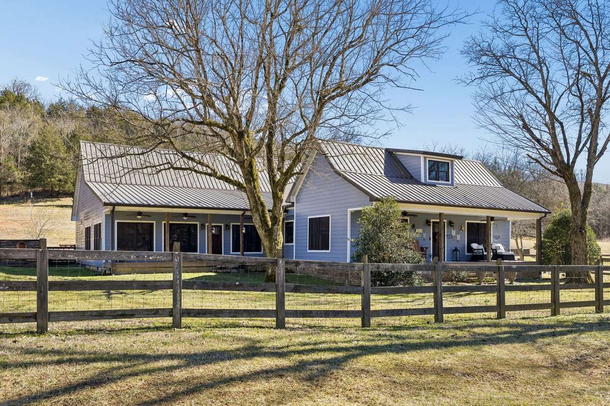 This is the exterior of the home with fiber cement board siding and metal roof. This home is nearly 4,000 sf of space inside!  The front yard is fenced, and there are two front covered porches!