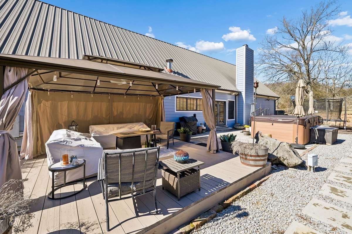 The back yard near the home has a deck with gazebo (which remains), and a swim spa (which will remain!
