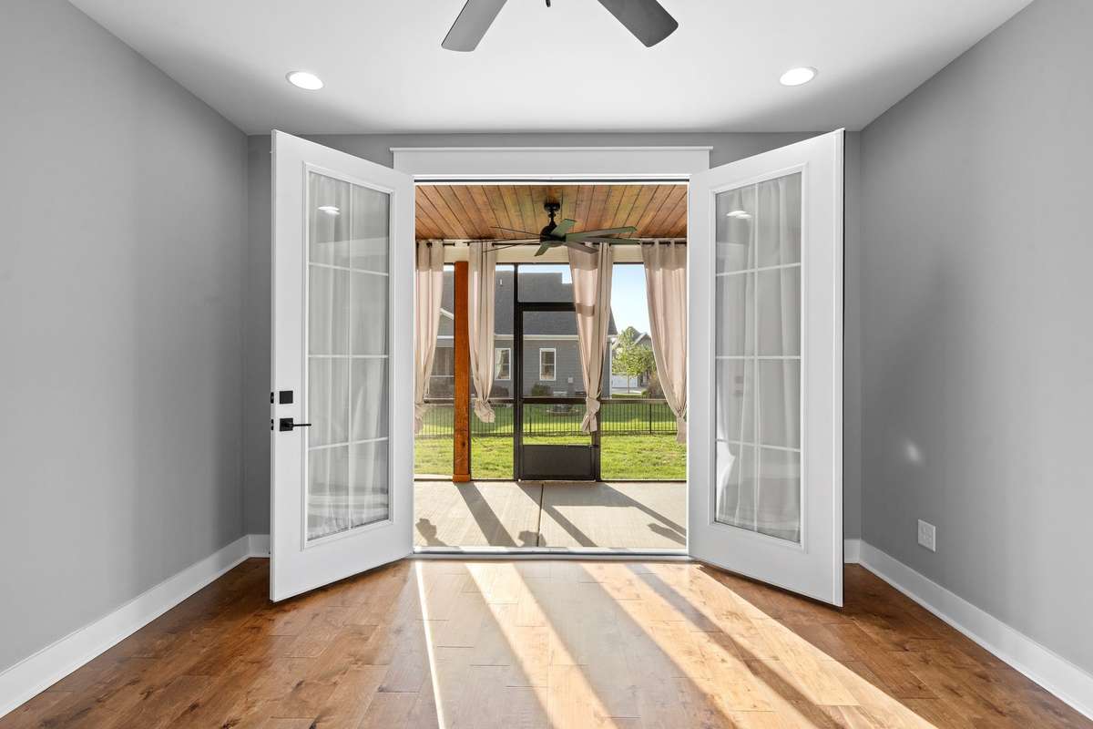 Seamless indoor-outdoor connection with French doors opening to the screened porch.