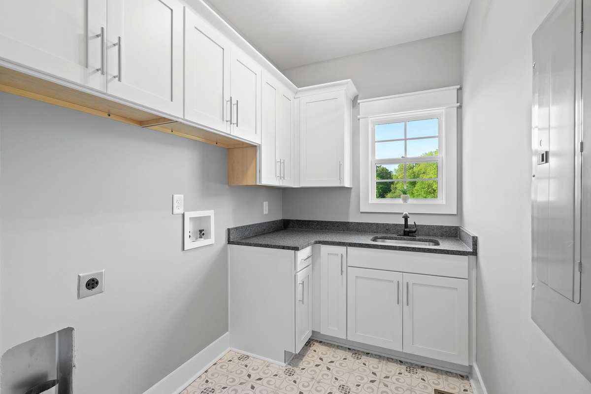 Oversized laundry room with cabinetry, folding space, and utility sink.